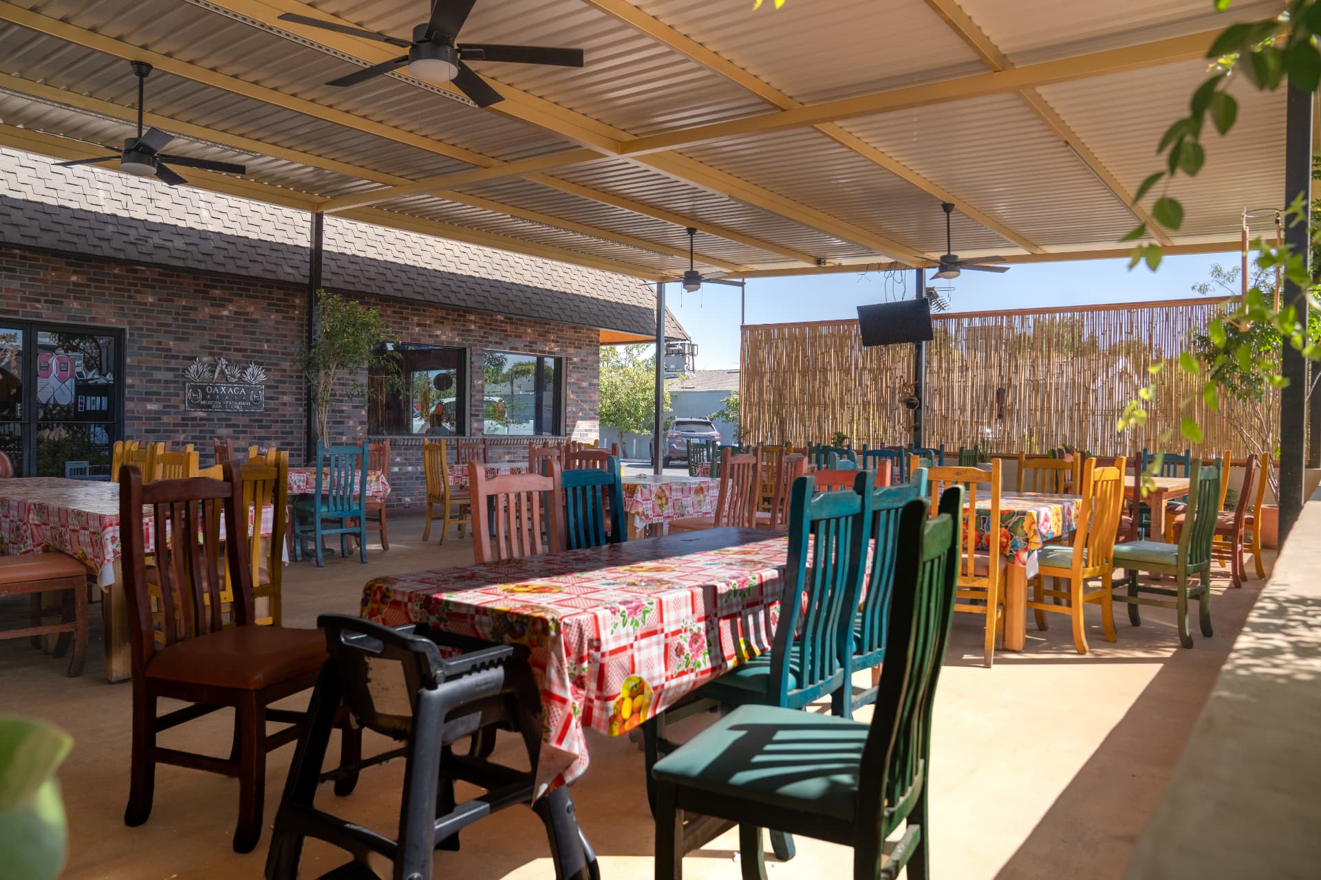 The covered patio with colorful chairs and floral tablecloths